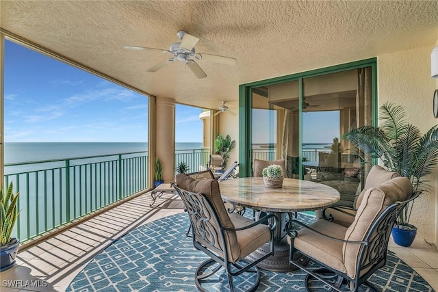 balcony featuring ceiling fan and a water view