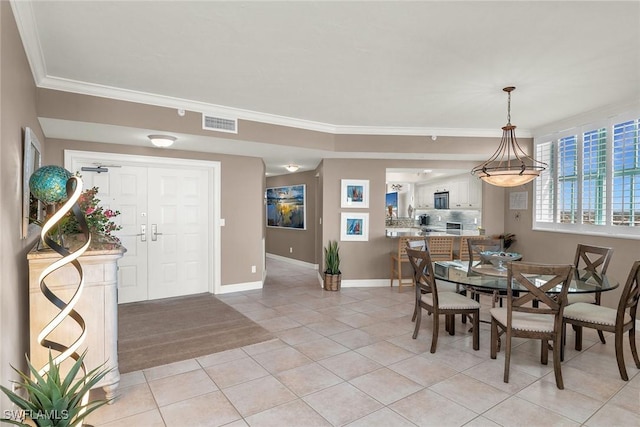 dining area featuring light tile patterned floors and crown molding