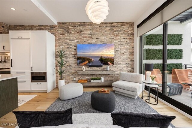 living room featuring light wood-type flooring and brick wall