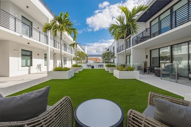 view of home's community with an outdoor living space, a patio, and a lawn