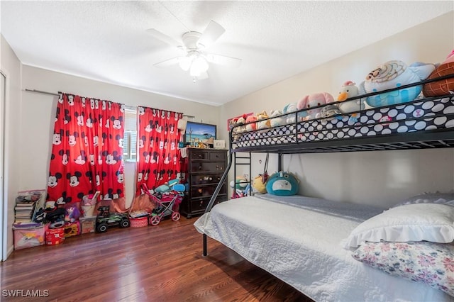 bedroom featuring ceiling fan, dark wood-type flooring, and a textured ceiling