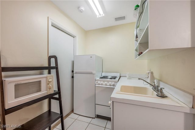 kitchen featuring white appliances, sink, and light tile patterned floors