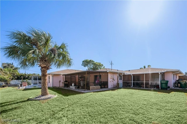 back of property featuring a lawn and a sunroom