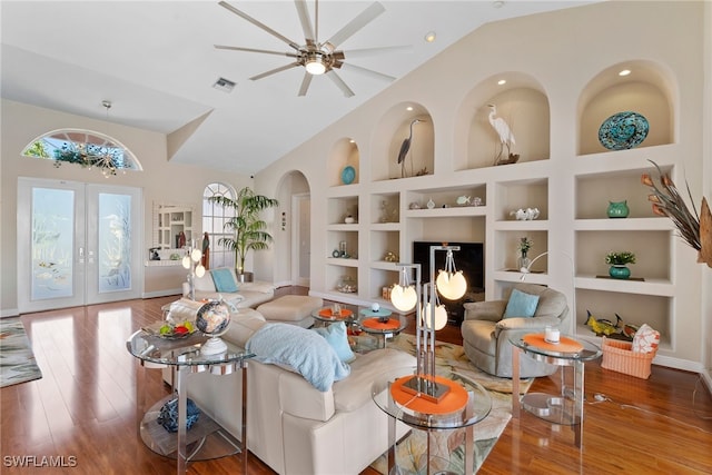 living room with hardwood / wood-style floors, french doors, vaulted ceiling, built in shelves, and ceiling fan