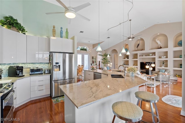 kitchen with built in shelves, white cabinetry, sink, and appliances with stainless steel finishes