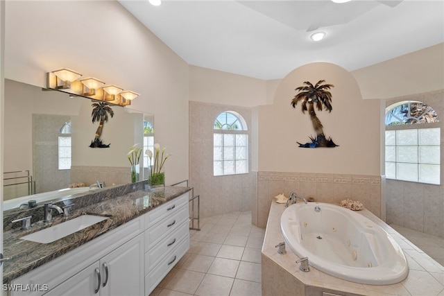 bathroom featuring tile patterned floors, vanity, and a relaxing tiled tub