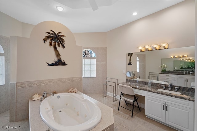 bathroom featuring tile patterned flooring, vanity, and tiled bath