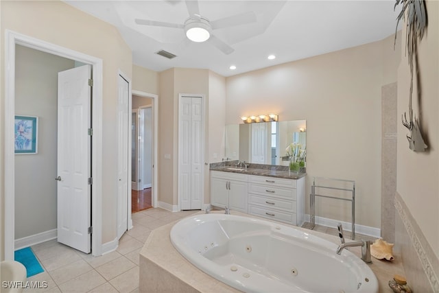 bathroom with tile patterned flooring, a relaxing tiled tub, ceiling fan, and vanity