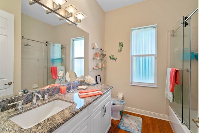 full bathroom with vanity, toilet, wood-type flooring, and combined bath / shower with glass door