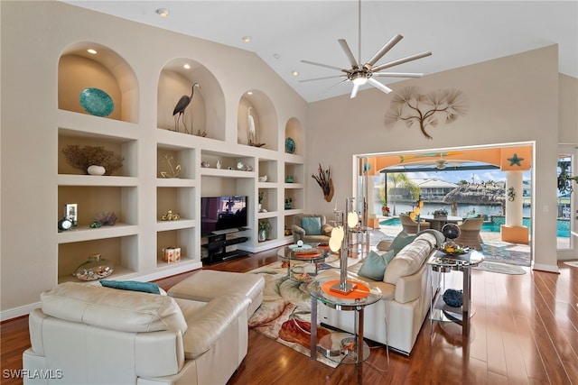 living room with built in shelves, ceiling fan, and dark hardwood / wood-style floors