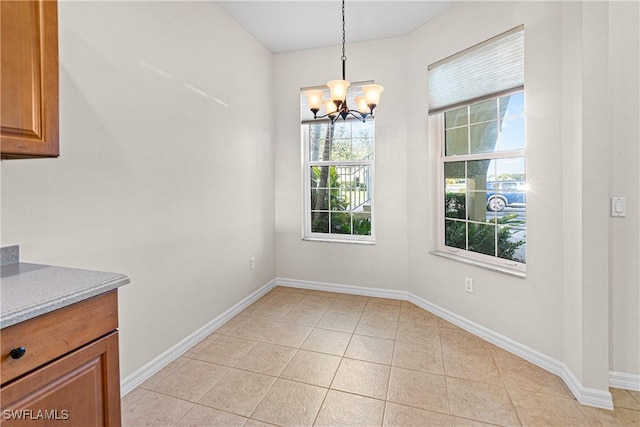 unfurnished dining area featuring a notable chandelier and light tile patterned floors