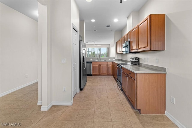 kitchen featuring appliances with stainless steel finishes, light tile patterned floors, ceiling fan, and sink