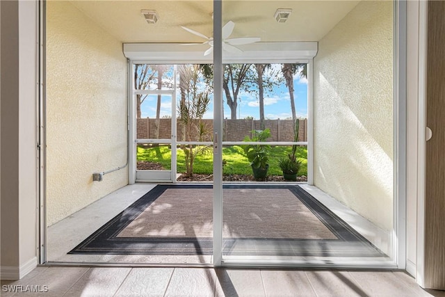 unfurnished sunroom with ceiling fan