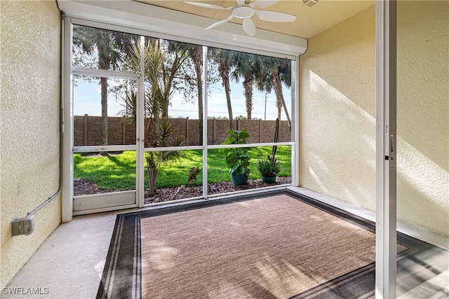 unfurnished sunroom with ceiling fan