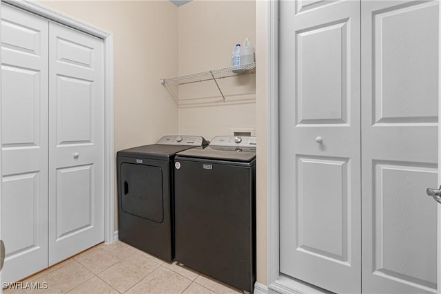 clothes washing area with light tile patterned floors and washing machine and clothes dryer