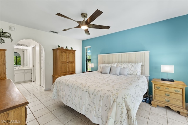 bedroom with ensuite bathroom, ceiling fan, and light tile patterned flooring