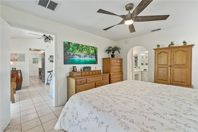 tiled bedroom featuring ensuite bath and ceiling fan