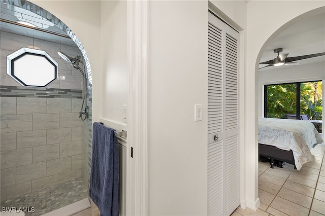 bathroom with tile patterned flooring, ceiling fan, and a tile shower