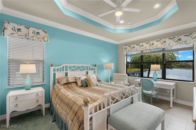 bedroom featuring ceiling fan, ornamental molding, light tile patterned floors, and a tray ceiling