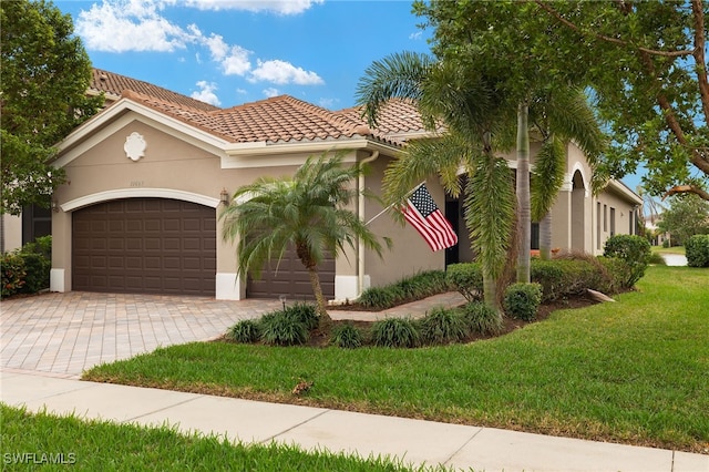 mediterranean / spanish house featuring a front yard and a garage