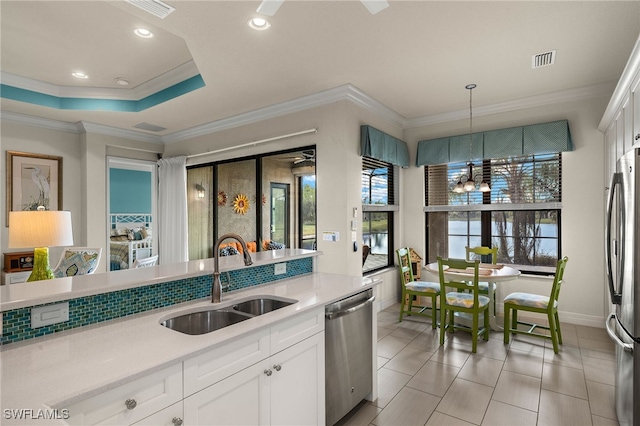 kitchen featuring stainless steel appliances, sink, decorative light fixtures, an inviting chandelier, and white cabinetry