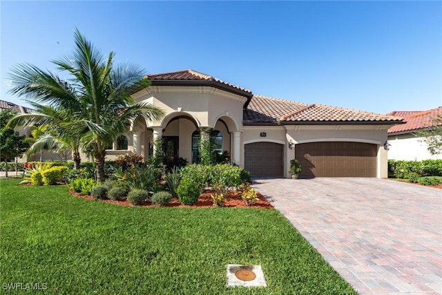 mediterranean / spanish-style home with a front lawn and a garage