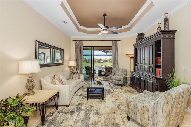 living room with ceiling fan, ornamental molding, and a tray ceiling