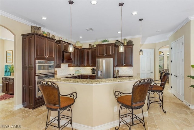 kitchen featuring a kitchen bar, appliances with stainless steel finishes, custom exhaust hood, dark brown cabinets, and decorative light fixtures