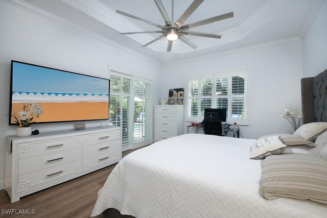 bedroom featuring access to outside, ceiling fan, dark hardwood / wood-style floors, ornamental molding, and a tray ceiling