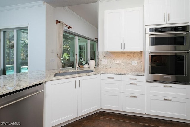 kitchen with white cabinetry, sink, light stone countertops, backsplash, and appliances with stainless steel finishes