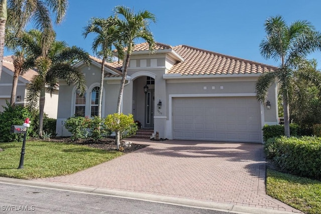 mediterranean / spanish-style home featuring a garage and a front yard