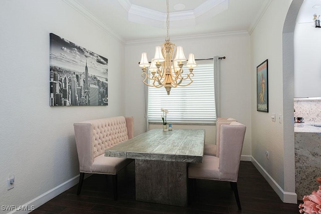 dining area with dark hardwood / wood-style flooring, ornamental molding, and an inviting chandelier