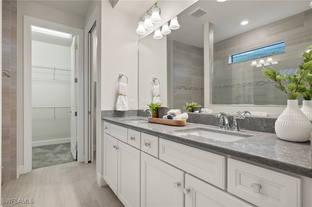 bathroom featuring a shower and vanity