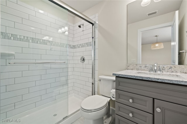 bathroom with vanity, toilet, and a shower with door