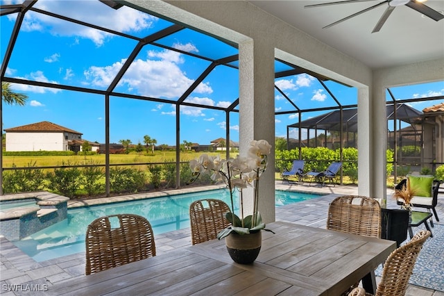 view of pool with glass enclosure, ceiling fan, an in ground hot tub, and a patio