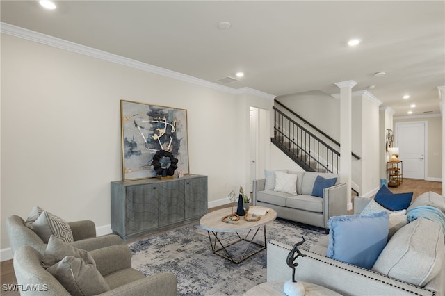 living room featuring wood-type flooring, crown molding, and ornate columns