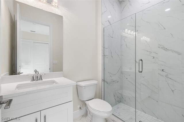 bathroom with marble finish floor, a marble finish shower, toilet, vanity, and baseboards