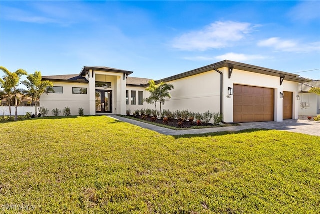 prairie-style home featuring a front yard, driveway, stucco siding, french doors, and a garage