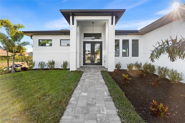 entrance to property with a lawn and french doors