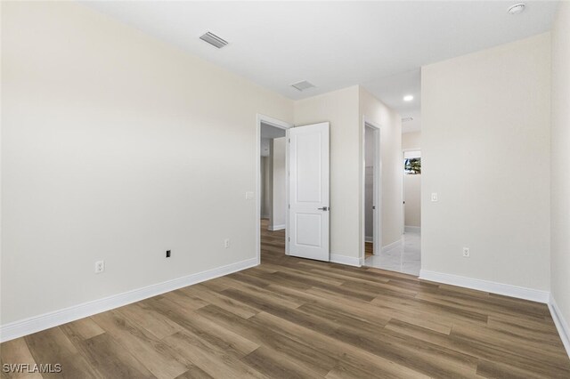 unfurnished bedroom featuring visible vents, baseboards, and wood finished floors