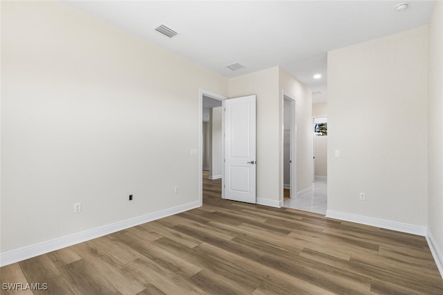 empty room featuring recessed lighting, visible vents, baseboards, and wood finished floors