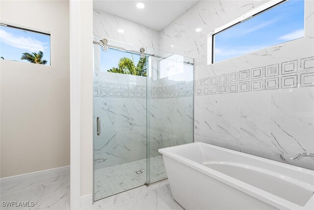 full bathroom featuring recessed lighting, baseboards, a freestanding bath, marble finish floor, and a marble finish shower