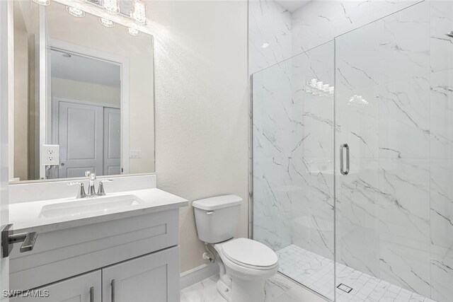 full bathroom featuring a marble finish shower, baseboards, toilet, marble finish floor, and vanity