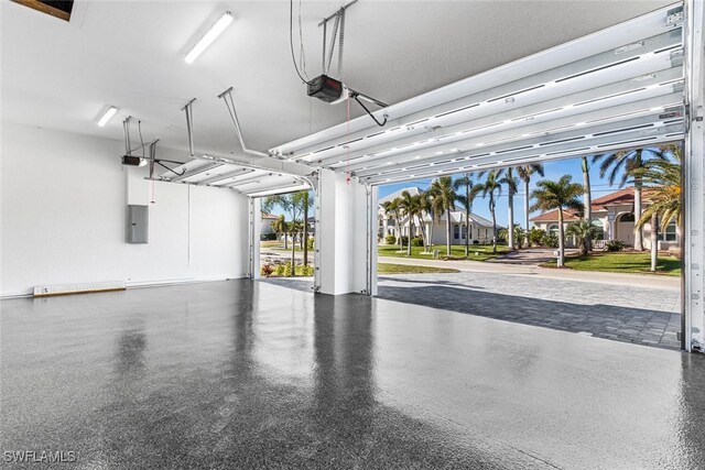 garage with a residential view, electric panel, and a garage door opener