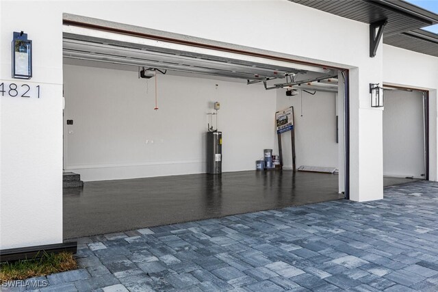 garage with a garage door opener and electric water heater