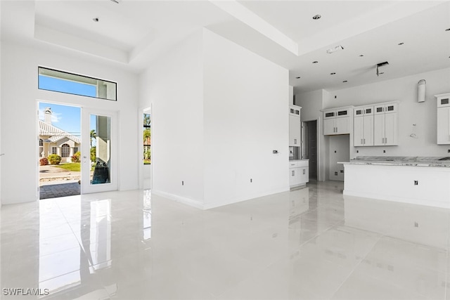 unfurnished living room featuring a raised ceiling