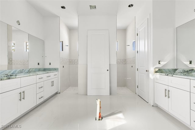 bathroom featuring vanity, tile walls, and tiled shower