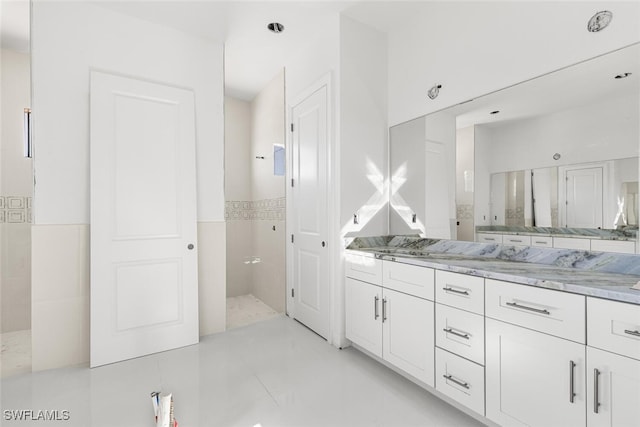 bathroom featuring vanity and tile walls