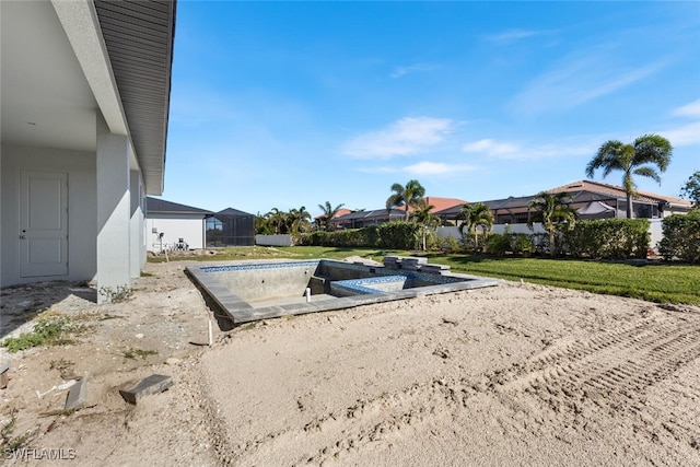 view of storm shelter with a hot tub and a lawn