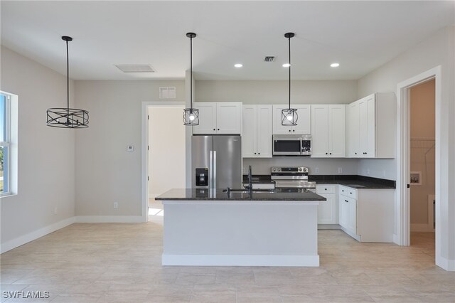 kitchen featuring stainless steel appliances, a kitchen island with sink, pendant lighting, and sink